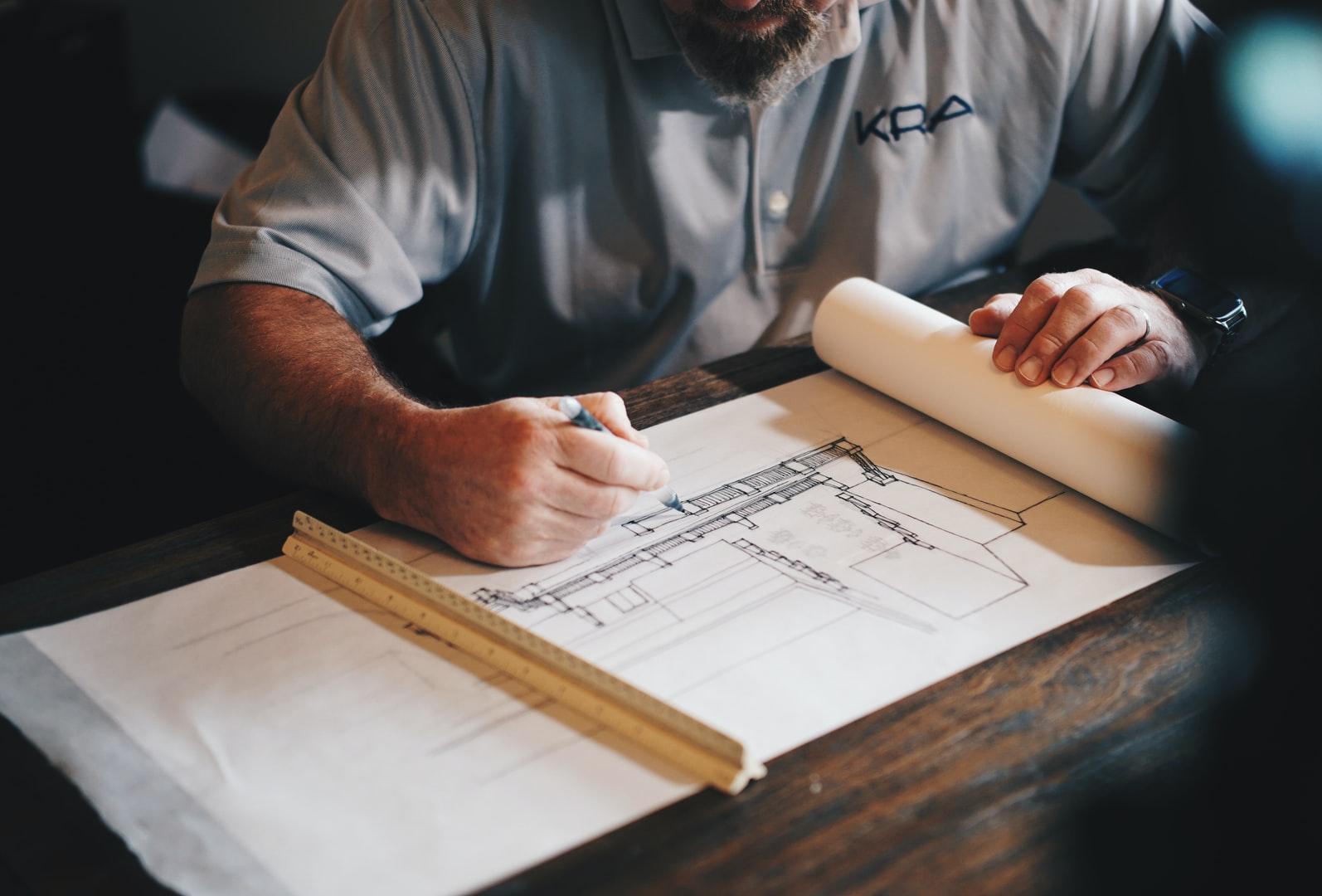 An architect working on a draft with a pencil and ruler